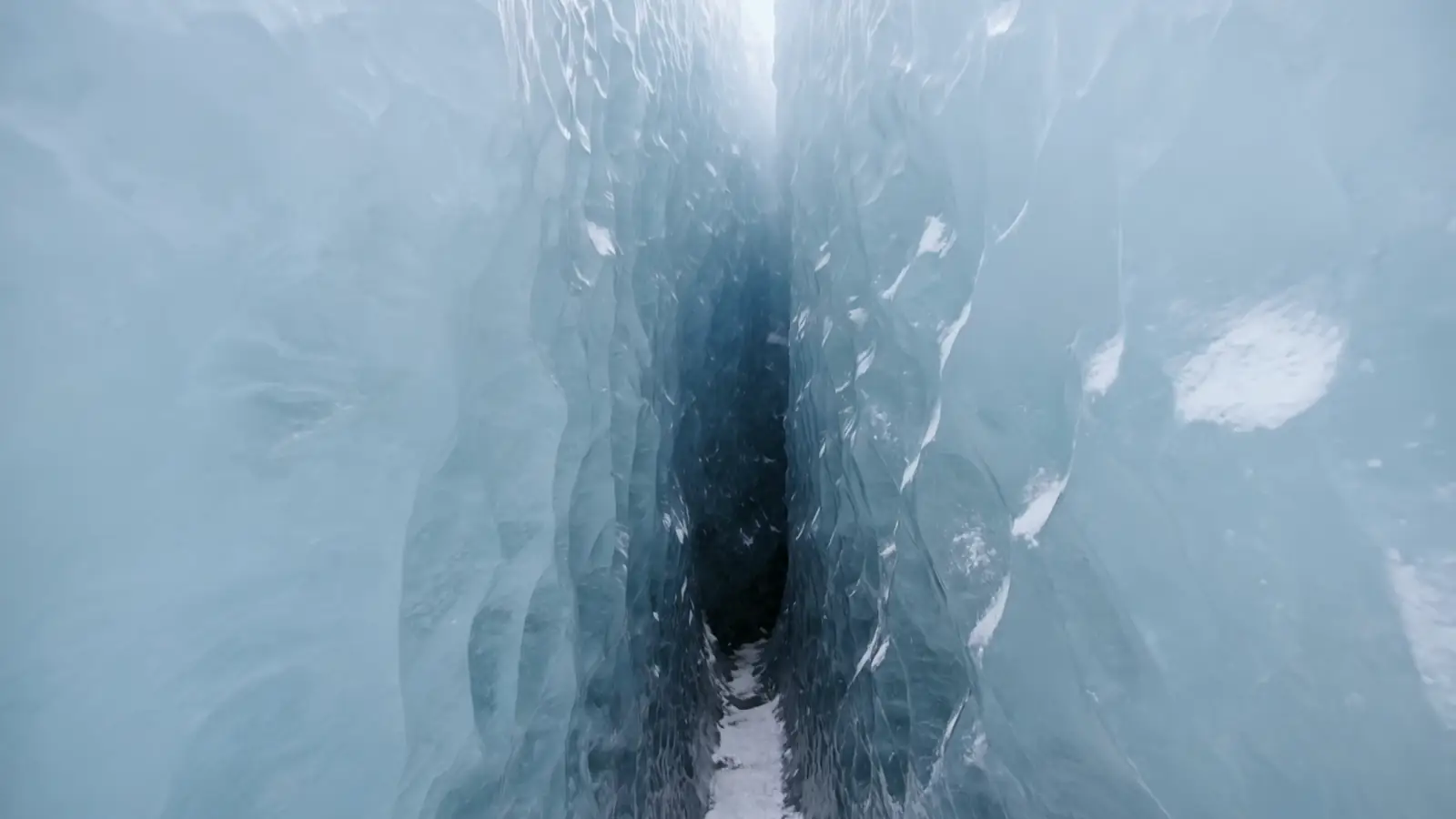 A vertical descent into deep blue glacial ice; the surface of the core.